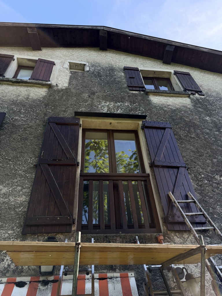 Volets en bois et garde-corps métalliques avant rénovation avec peinture écaillée et traces d’usure.